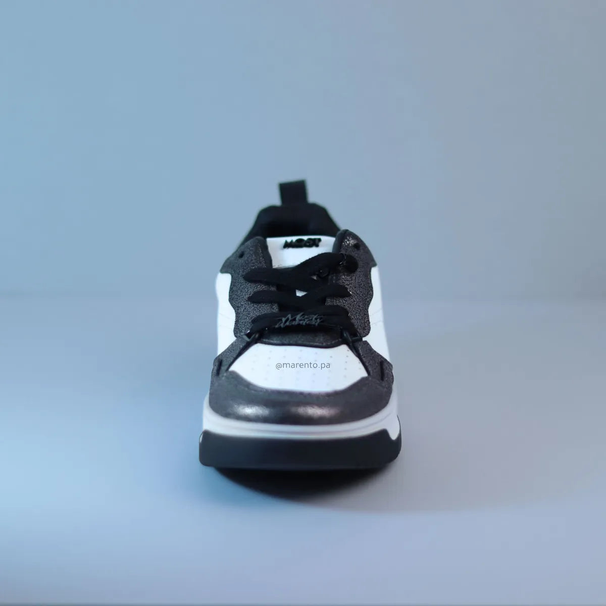 Vista frontal zapatillas mujer detalle placa metálica en cordones y textura brillante