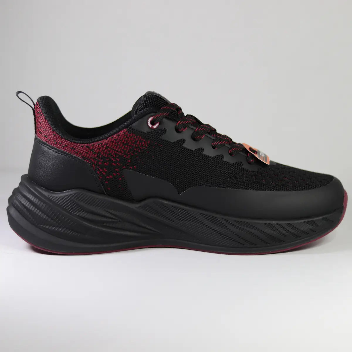 Vista lateral interna zapatillas deportivas hombre negro y rojo tejido transpirable