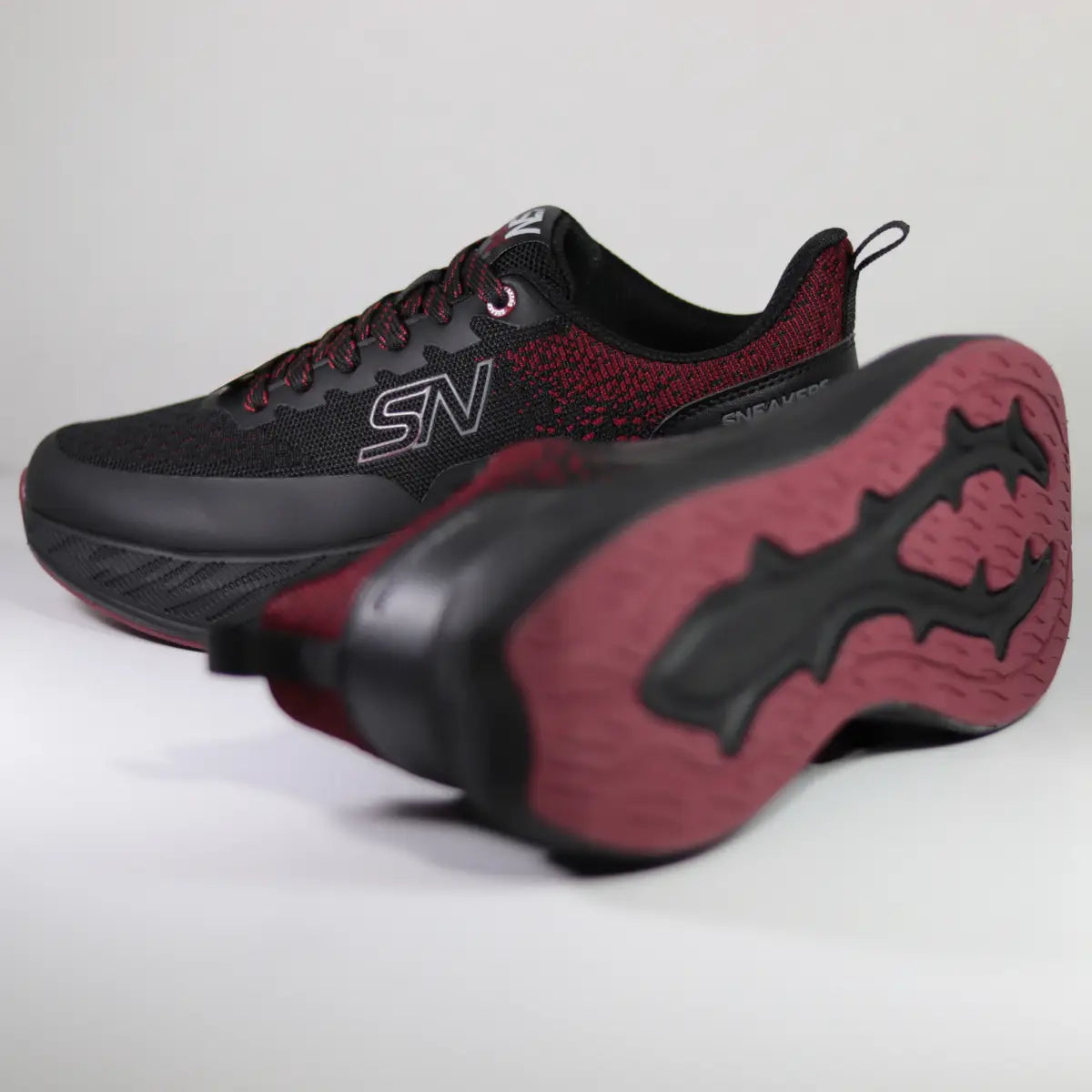 Zapatillas negras y rojas hombre mostrando suela de goma tracción deportiva