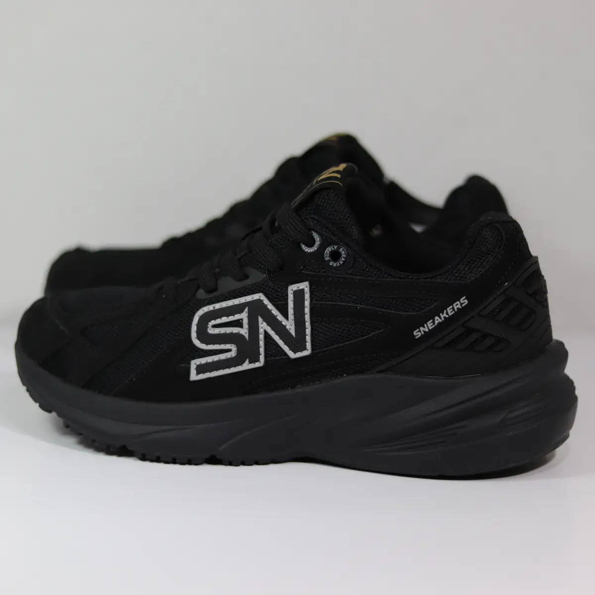 Par de zapatillas chunky negras mujer con logo plateado y detalles dorados en lengüeta