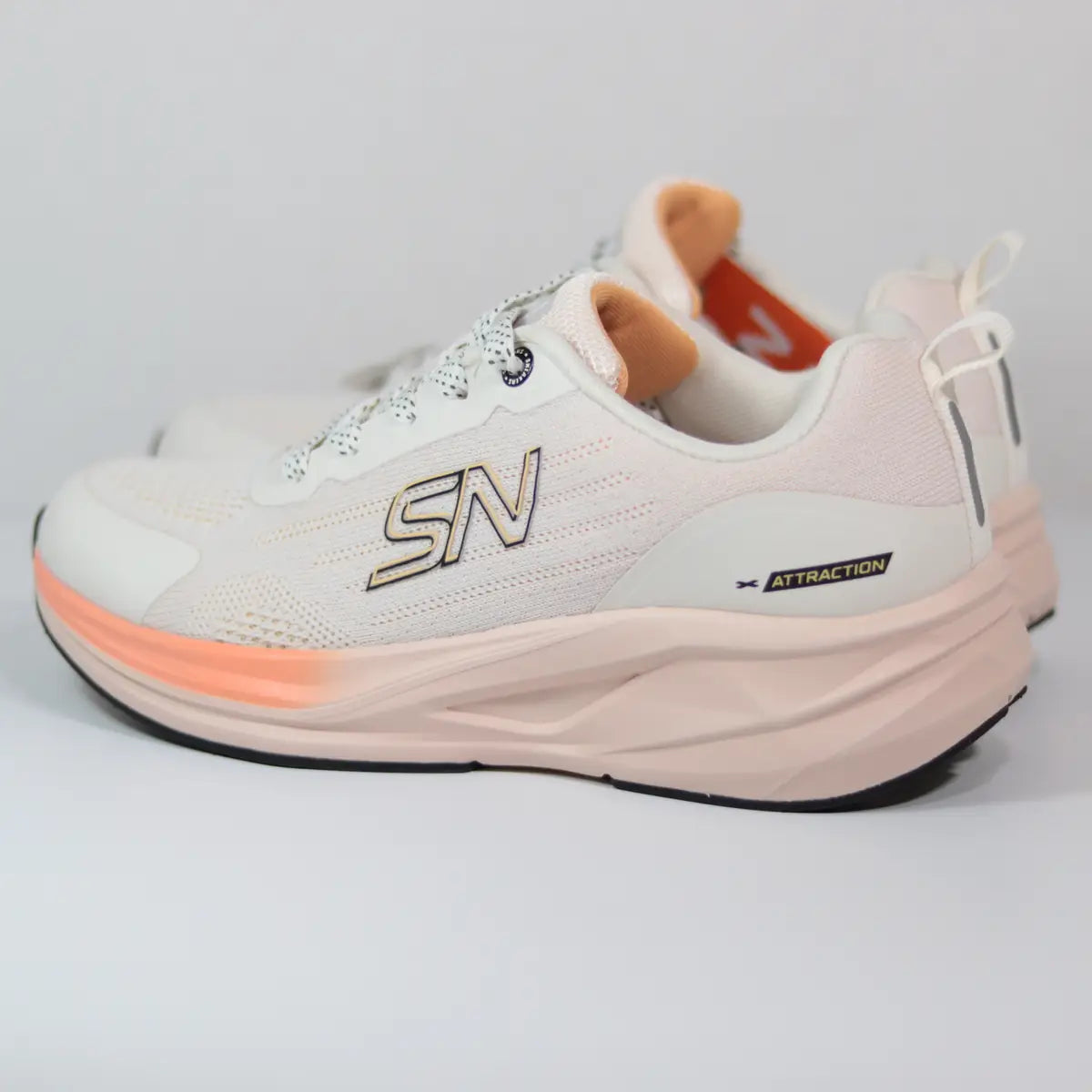 Par de zapatillas mujer Sneakers Supply tono beige nude con detalles sutiles en naranja pastel