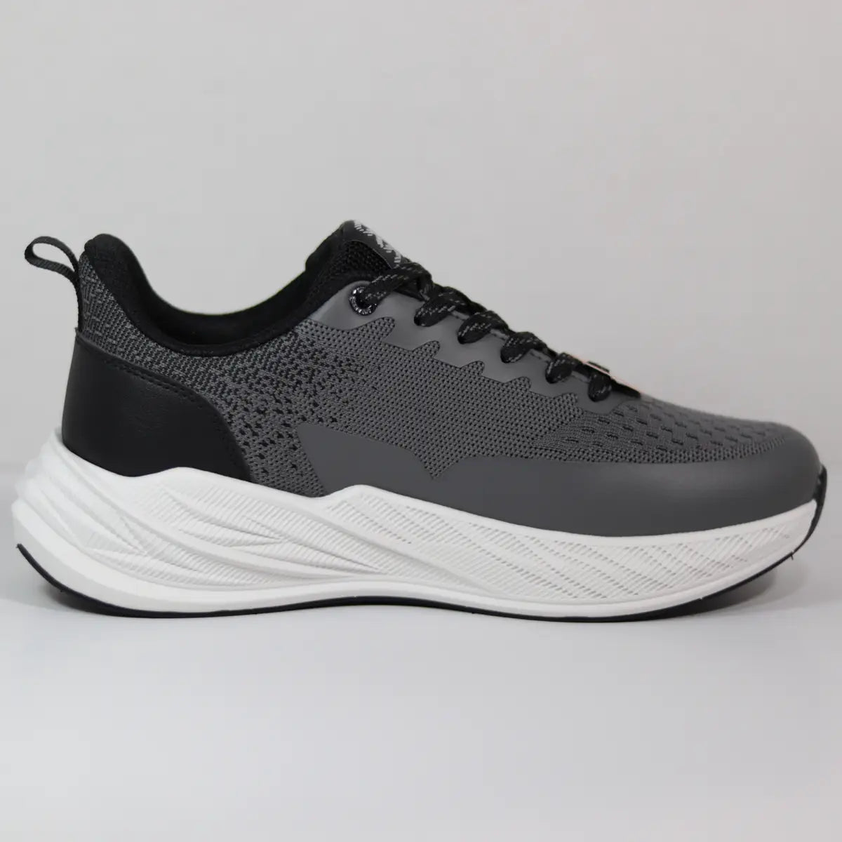 Vista lateral interna zapatillas gris y negro hombre malla transpirable textura deportiva