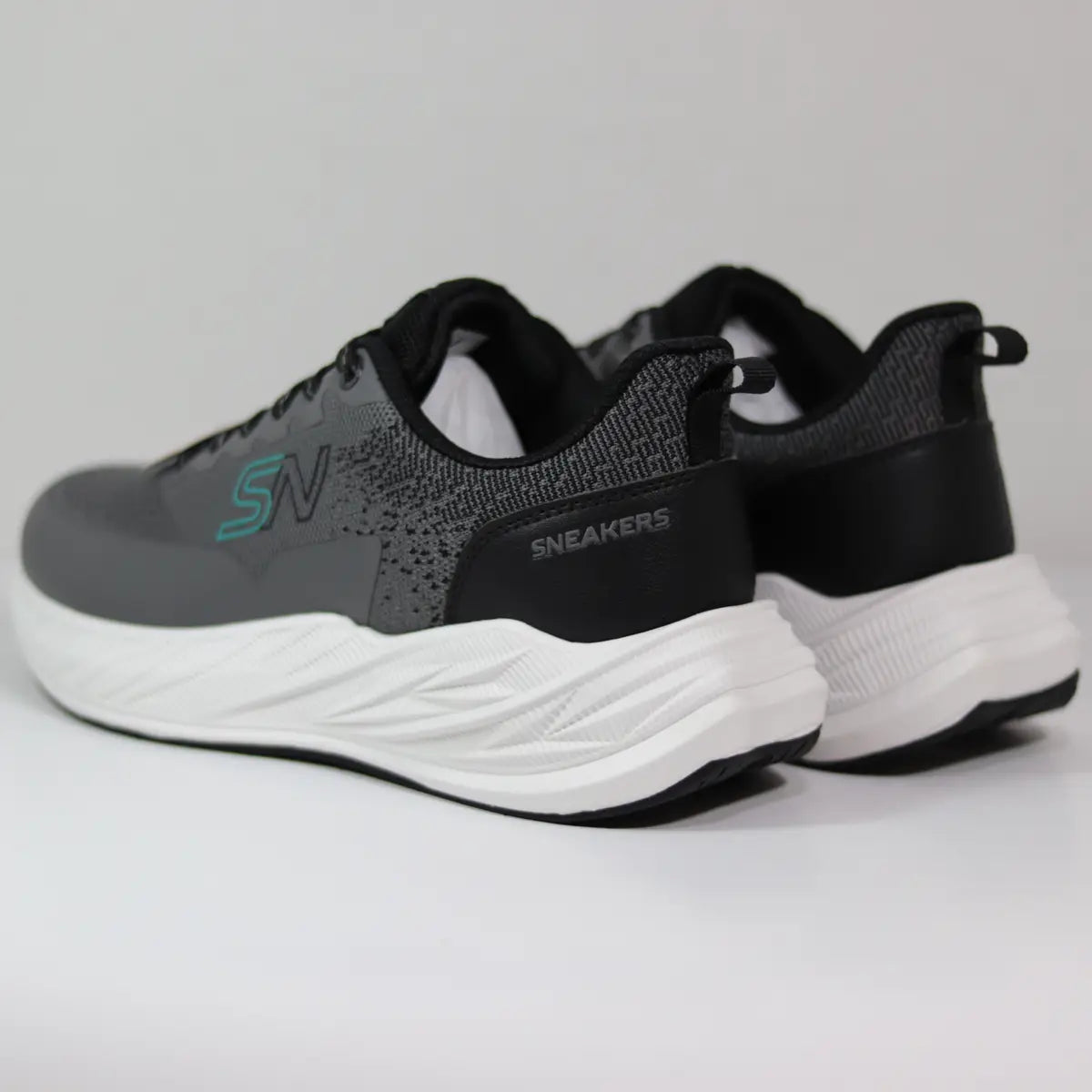 Vista trasera talón zapatillas hombre negras y grises con suela gruesa amortiguada blanca