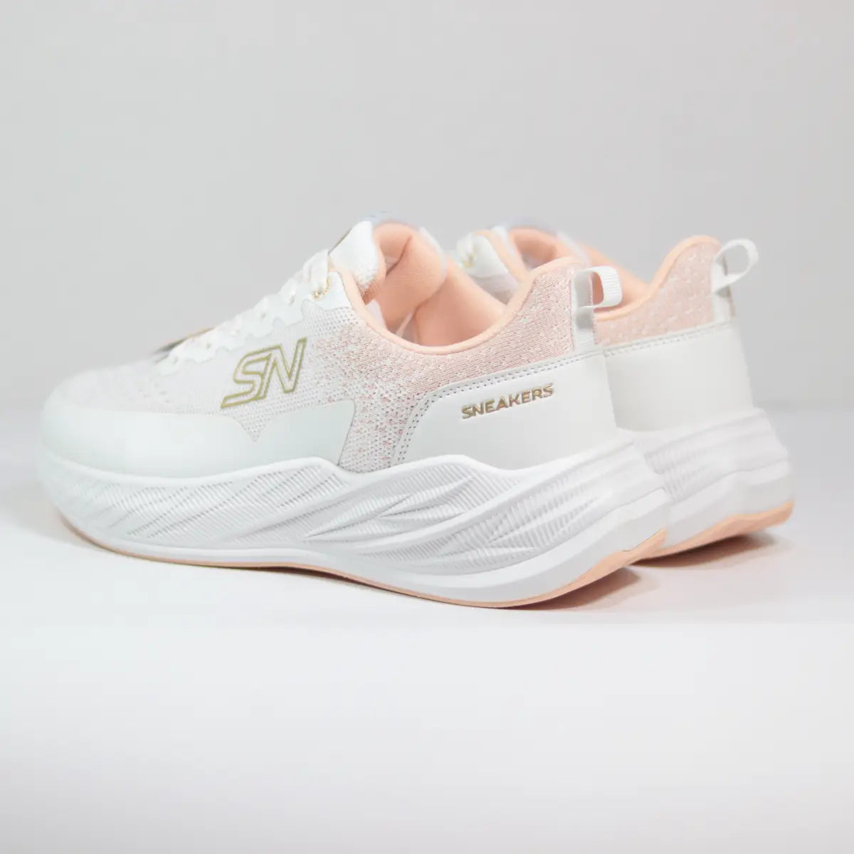 Par de zapatillas deportivas mujer blancas con detalles dorados y cuello texturizado vista en ángulo