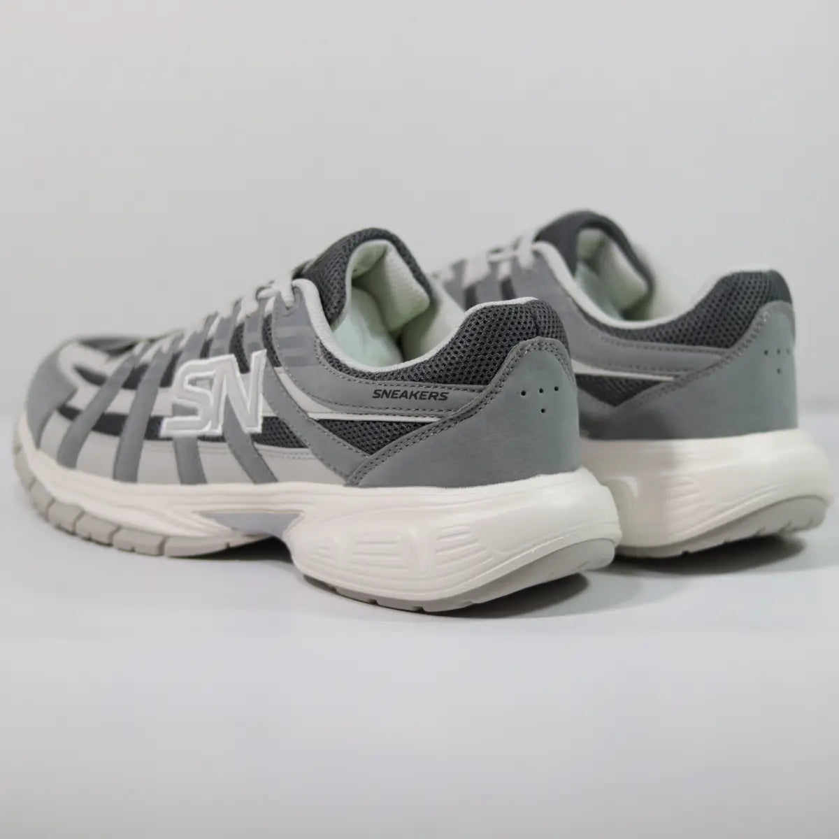 Vista trasera talón zapatillas hombre grises entresuela chunky esculpida y detalles reflectantes