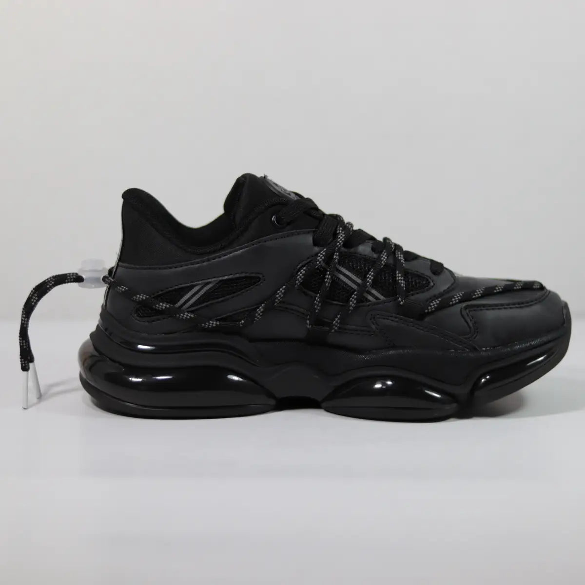 Vista lateral interna zapatillas urbanas hombre negras diseño techwear con cordones ajustables