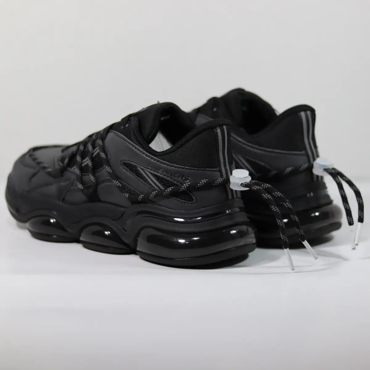 Vista trasera zapatillas hombre negras entresuela de burbujas y ajuste de cordón en el talón