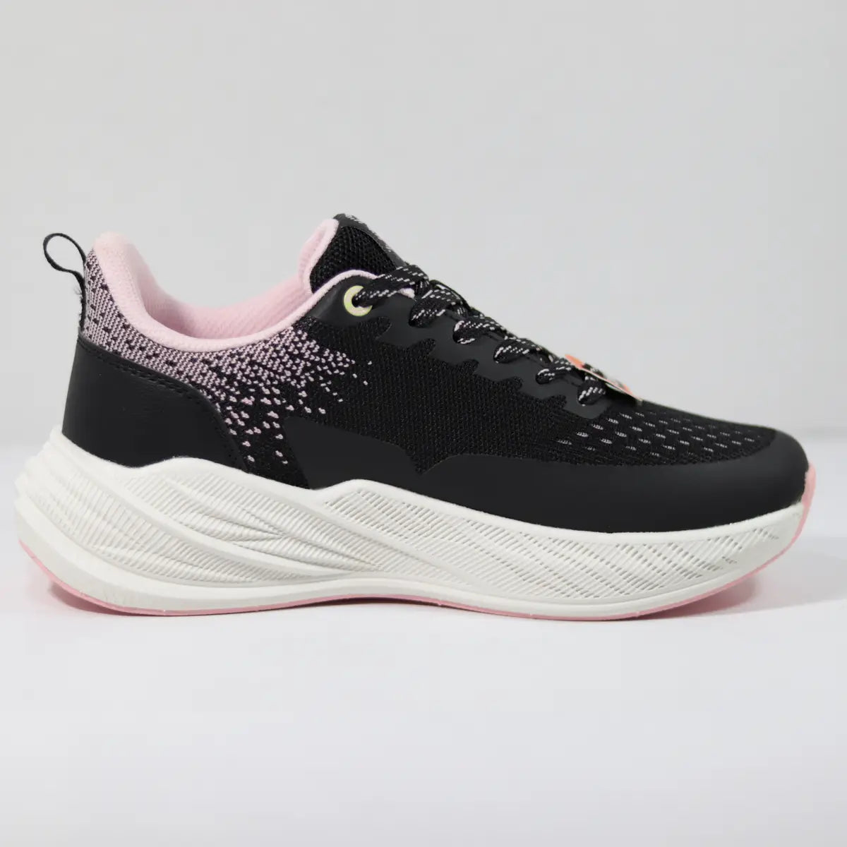 Vista lateral interna zapatillas deportivas mujer negras con tejido rosa pastel y entresuela blanca