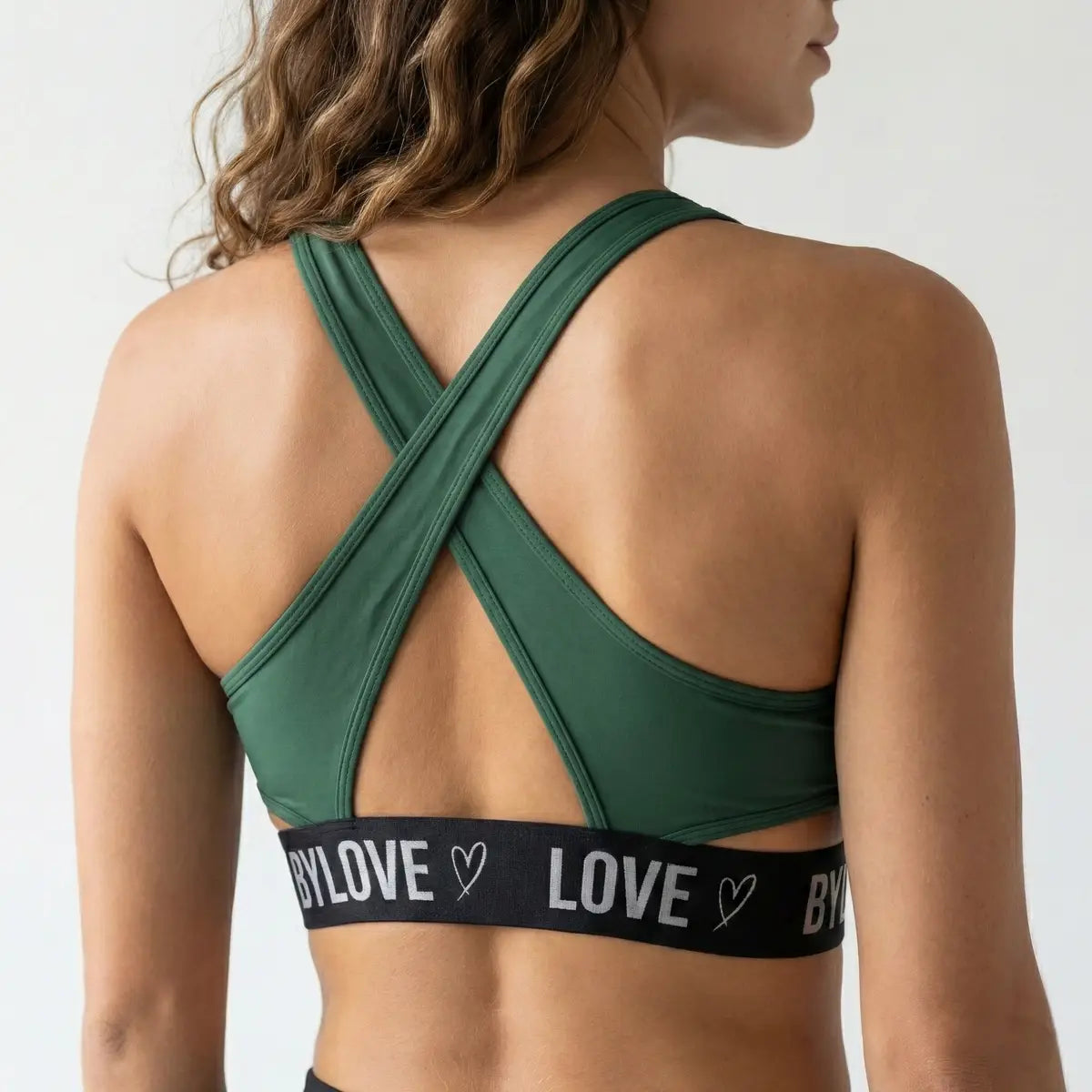 Detalle espalda cruzada top deportivo verde marca BYLOVE mujer fitness