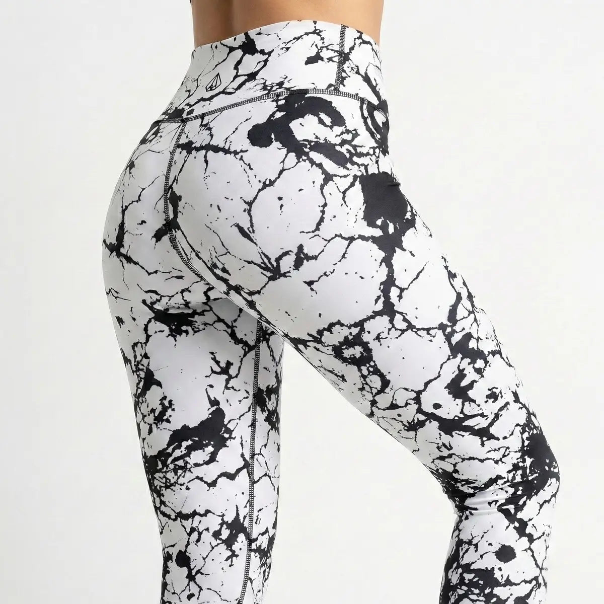Mujer vistiendo leggings de mármol blanco y negro BJX fitness disimula celulitis