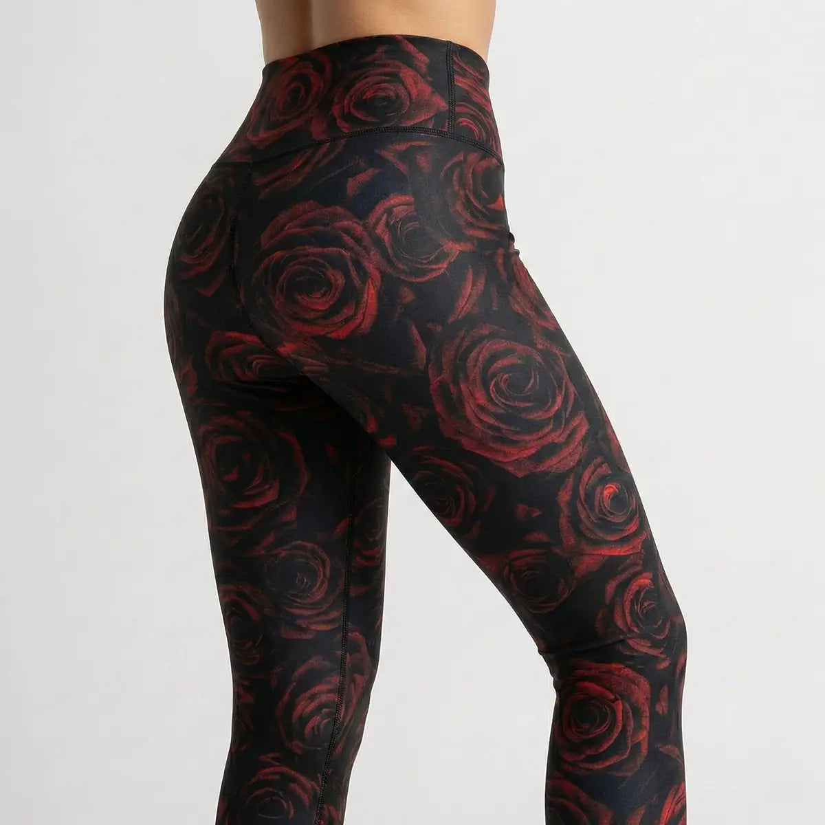 Mujer vistiendo leggings de rosas rojas cintura alta estilo romántico fitness