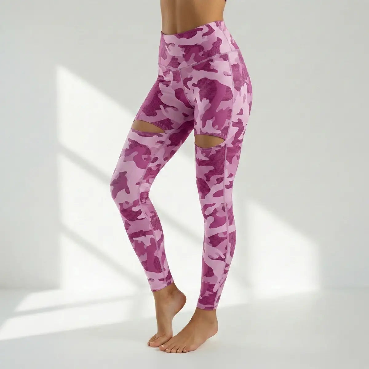 Mujer vistiendo leggings camuflados rosa con rotos en las piernas fitness moda