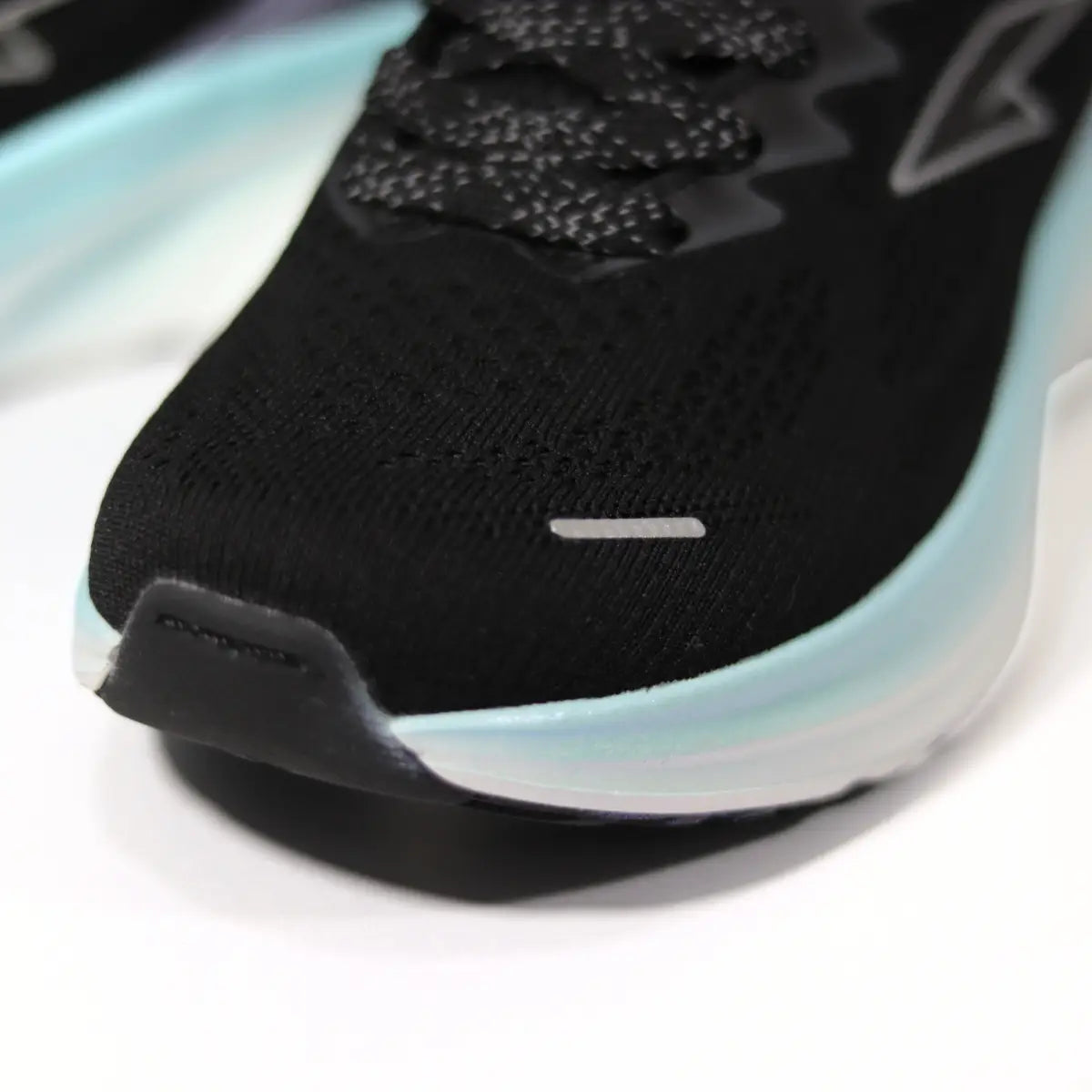Primer plano textura malla negra y logo RS Performance en zapatilla mujer Protec.